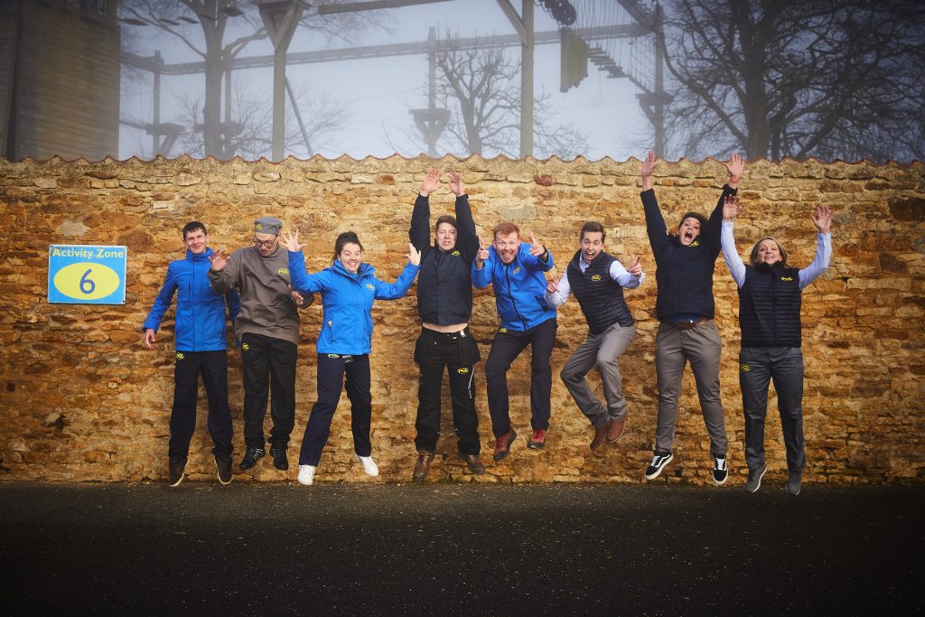 Various PGL colleagues jumping next to a wall