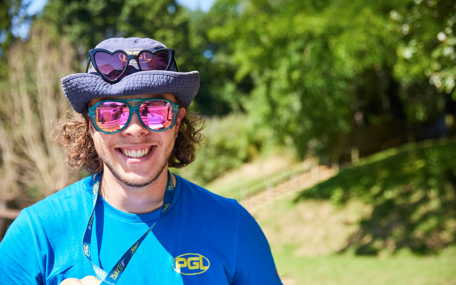 A smiling PGL employee in sunglasses