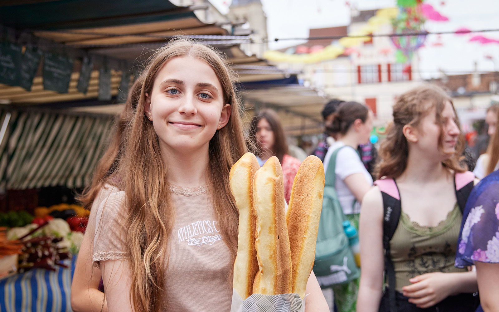 Guest holding baguettes at a French market