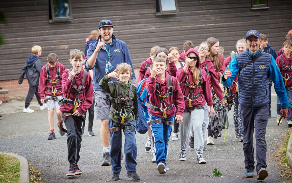 Two PGL employees leading a group of children