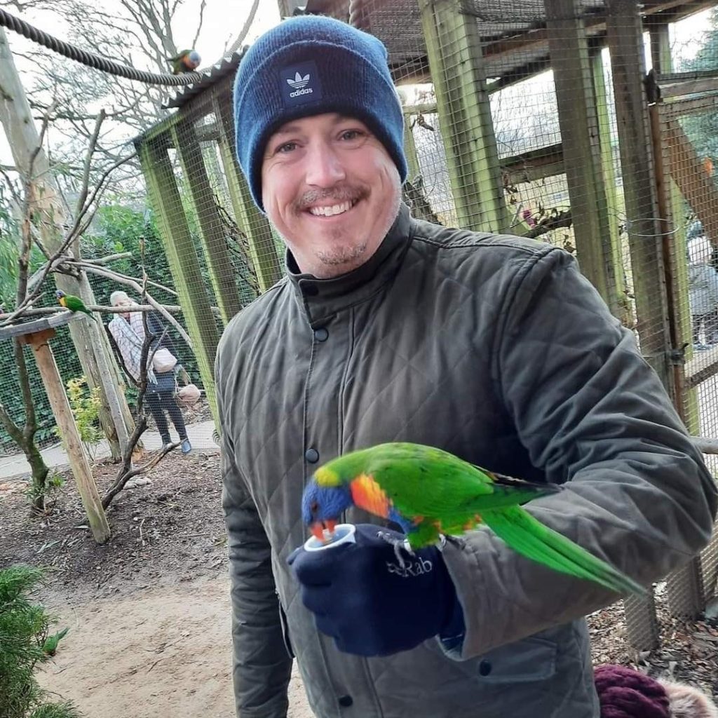 The general manager of Little Canada holding a parrot