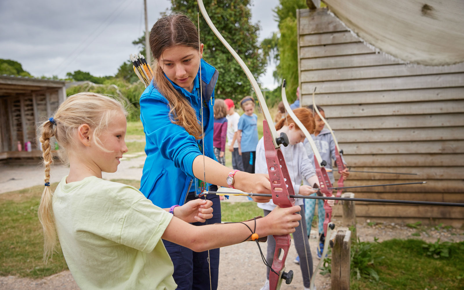 Activity Instructor teaching archery to a girl